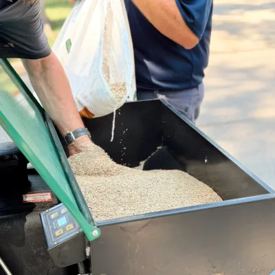 DreamLawn pros adding seed to a seeder