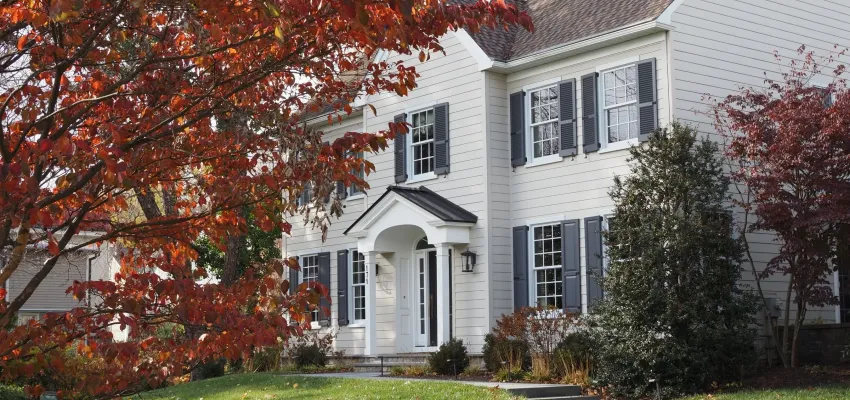 A house with a tree out front with red leaves