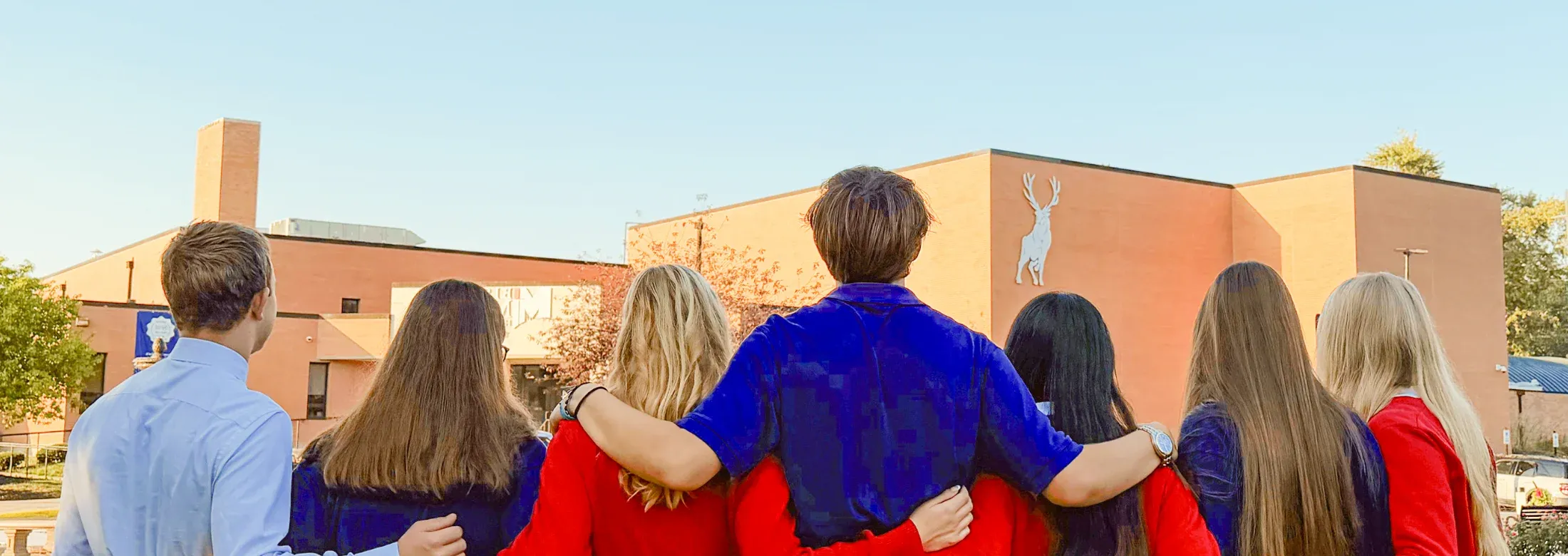 students arm in arm outside of school