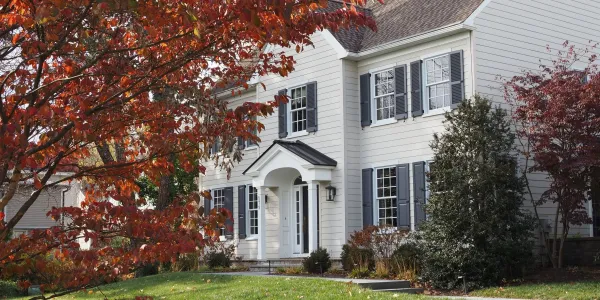 A house with a tree out front with red leaves