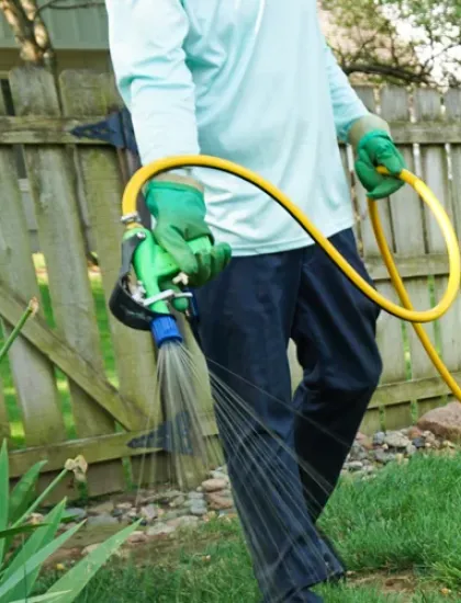 DreamLawn technician spraying weed control treatment on a residential Kansas City lawn